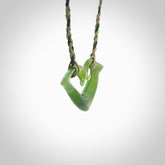 This photo shows a koru pendant carved from New Zealand Jade. The artist, Shaun Gardiner, has carved this beautifully. We provide this piece with a fixed length cord in a two toned green colour. This is a fantastic work of art, we have one only.